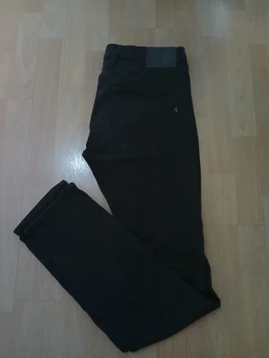 Svarta Replay Anbass jeans herr. - Säljer ett par svarta Replay Anbass jeans i herrmodell. De har en slim passform med klassisk femficksdesign och snygga detaljer på bakfickan. Jeansen är tillverkade i stretchigt bomullsmaterial för extra komfort och har en stilren look som funkar till många outfits. W34, L34. Nypris: 849kr / Mitt pris: 449kr