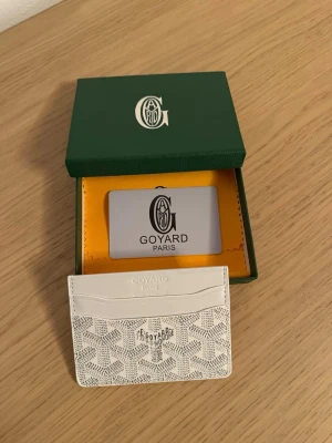 Vit korthållare - Säljer en stilren vit korthållare med deras ikoniska mönster i.... Plånboken har flera kortfack och är tillverkad i exklusivt skinn. Kommer med original ask och certifikat. Perfekt för dig som vill ha något ly, men ändå diskret. Skickar produkten snabbt Dm mig om ni har frågor😁