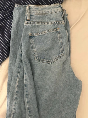 Blåa jeans  - Säljer ett par blåa jeans i storlek 32, raka med hög midja. Jättefina men kommer tyvärr inte till användning. Från nakd och i bra skick 