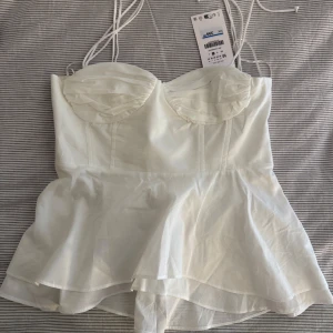 Vit korsettopp med knytband - Säljer denna jätte söta vita korsettopp med knytband från Zara. Storlek Xs. Nypris 399 SEK. 