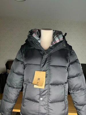 Burberry Vinterjacka/Väst - Helt ny och oanvänd Burberry Jacka som kan göras till en väst. Perfekt för den kalla vintern vi har nu, taggarna sitter kvar och den är i storlek M! Pris kan självklart diskuteras så kom med rimliga bud!