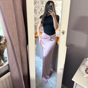 Ljusrosa långkjol med slits - Fin festkjol som aldrig kommit till användning. Har en slit i sidan och är ganska lång på mig som är 160cm