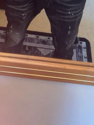 Svarta Dsquared2 jeans med slitningar - Säljer ett par svarta Dsquared2 jeans med coola slitningar och färgstänk. Jeansen har en snygg tvättad look och patch med Dsquared2-logga bak på fickan. Klassisk femficksmodell och raka ben. Perfekta för dig som gillar streetwear och vill sticka ut.