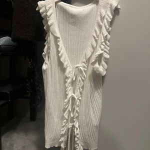 Vit linnetopp med volang - Supersöt vit linnetopp med volangkant längs urringningen och knyt framtill.