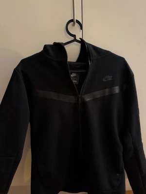 Nike tech hoodie - Svart Nike tech hoodie i fint skick. Storlek M på den men känns lite mindre i storlek enligt mig så skulle säga de är närmare en S. Hör av er vid frågor & funderingar. Mvh