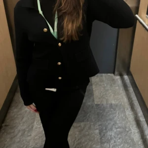 Marinblå tröja med guldknappar - Stilren kofta med snygga guldknappar framtill och två fickor. Klassisk krage och figurnära passform