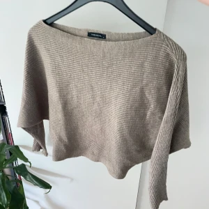 Beige ribbad croppad topp Trendyol - Säljer en beige ribbad croppad topp från Trendyol. Toppen har lös passform, lång ärm och bred halsringning. Perfekt för dig som gillar en chill och avslappnad stil. Materialet är mjukt och stretchigt, vilket gör den superbekväm.