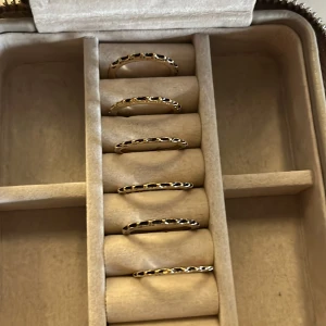 Set med sex guldiga ringar - Säljer ett set med sex tunna ringar i guldton. Ringarna har ett coolt, hålat mönster runt om som ger en unik och trendig look. Perfekta att bära tillsammans på ett finger eller sprida ut på flera. 