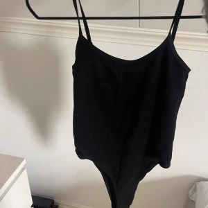 Svart body med smala axelband - Enkel och stilren svart body med smala, justerbara axelband.