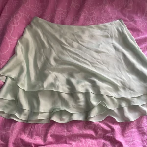 Sommar kjol  - En flowig lätt mint grön kjol med 3 layers från Primark, satin som är väldig lätt med dragkedja på sidan! Säljer den då den aldrig kommit till användning! M/L? !!Katt finns i hemmet!!