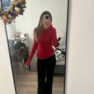 Röd långärmad topp från Intimissimi - Slimmad röd långärmad topp från Intimissimi i ultralätt material med kashmir. Tunn och mjuk känsla, perfekt för lager-på-lager eller som statement-piece. Enkel design utan mönster, rund halsringning och figurnära passform.