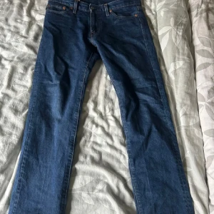 Levi's 511 blå jeans W30 L30 - Säljer ett par klassiska Levi's 511 jeans i blå denim. Modellen är slim fit med raka ben och normal midja. Jeansen har fem fickor, dragkedja och Levi's ikoniska läderpatch bak. Perfekta till en avslappnad stil och funkar året runt.