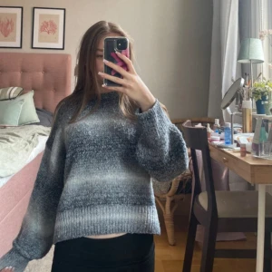 Grå stickad tröja från H&M Divided XS - Mysig stickad tröja från H&M Divided i storlek XS. Tröjan har ett snyggt melerat mönster i olika nyanser av grått och vitt, med breda ribbade muddar och avslappnad passform. Perfekt för lager på lager under kyliga dagar.