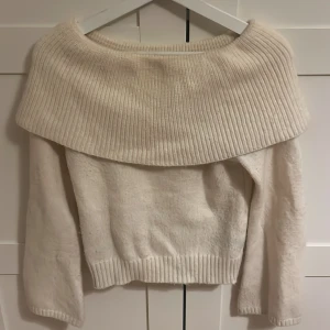 Vit offshoulder stickad tröja SHEIN - Superfin vit stickad tröja från SHEIN i offshoulder-modell. Tröjan har bred ribbad krage som vilar över axlarna och långa ärmar. Perfekt till hösten 