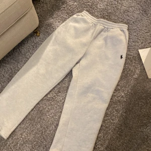 Grå mjukisbyxor från Polo Ralph Lauren - Snygga ljusgrå mjukisbyxor från Polo Ralph Lauren med klassisk broderad logga på höften. Byxorna har resår i midjan och är gjorda i mjuk bomullsmix som är riktigt skön. Perfekta för chill eller när du vill ha en avslappnad look. Pris kan diskuteras