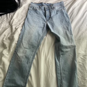 Levi's  ljusblå jeans straight fit - Klassiska Levi's jeans i ljusblå denim med raka ben och normal passform. Byxorna har fem fickor, knappgylf och den ikoniska läderpatchen bak i midjan. Perfekta för dig som gillar en tidlös och avslappnad stil.