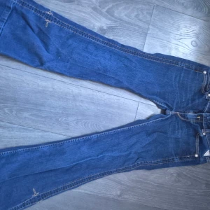 Blå Replay jeans bootcut W29 L32 - Hej tjejer. 💕 Säljer ett par klassiska blå jeans från Replay med bootcut-snitt och snygga kontrastsömmar. Bakfickorna har Replay’s ikoniska broderi. Jeansen är i denim och har en normal passform. Perfekta för dig som gillar en tidlös look med lite utsvängda ben.