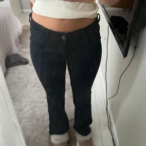 Svarta bootcut jeans låg midja - Säljer ett par svarta jeans med låg midja och bootcut-ben. Från diesel de är lite missfärgade men gör att fixa lätt med en svart textilfärg 