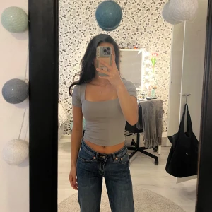 Grå croppad topp från Amisu - Säljer en stilren grå croppad topp från Amisu med fyrkantig ringning och korta ärmar. Toppen har en tight passform som framhäver figuren. Använd ett fåtal gånger så är som ny!  