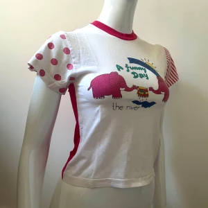 🐘Vintage babytee - Jättesöt vintage babytee i bomull med elefanter och gullig text. Prickig och randig på ärmarna och mörkrosa där bak och i halslinningen 💕Lite tråddragning och urtvättad pga vintage men fortfarande väldigt fin