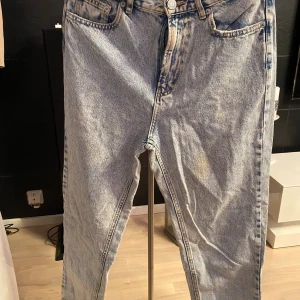 Ljusblåa straight jeans i vintage-stil - Säljer ett par ljusblåa jeans med klassisk tvätt och raka ben. Jeansen har fem fickor, normal passform och hög midja. Perfekta för dig som gillar retrovibbar och vill ha en avslappnad look. Materialet är 100% bomull för en skön känsla.