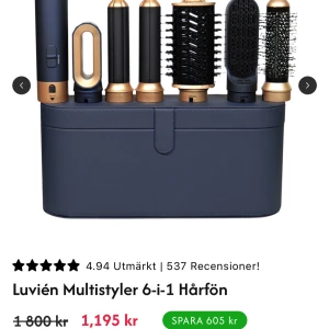 Luvién Multistyler 6-i-1 Hårfön - Luvién Multistyler 6-i-1 är en mångsidig hårfön med flera utbytbara tillbehör för styling, torkning och volym. Elegant design i svart och guld, levereras med praktisk förvaringsväska. Produkten ser ut att vara i nyskick utan synligt slitage.