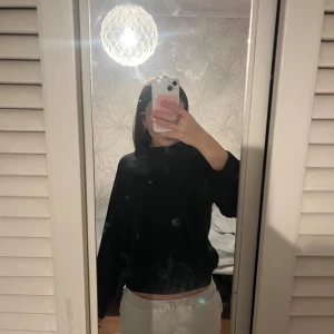 Svart ribbad stickad tröja - Säljer en svart stickad tröja med ribbad struktur och högre krage. Tröjan har lång ärm och en lite boxig, loose passform som är superenkel att styla till jeans eller mjukisbyxor. Perfekt för kyliga dagar när du vill vara både bekväm och snygg.