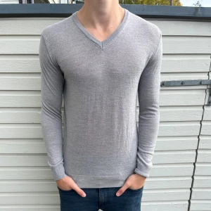  v-ringad merinoull tröja - Säljer en stilren ljusgrå v-ringad tröja från Zara Man i 100% extrafin ull. Inköpt för 1300kr men säljs nu för 349kr. Skick 9/10 som ny utan defekter. Hör gärna av er vid funderingar. 