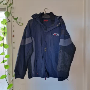 Fjällräven jacka i blå-grå-svart - Fjällräven jacka i blå-grå-svart. Enda tecknen på användning är lite lätta noppror på armbågarna. (Zooma in på 2a bilden för att se)