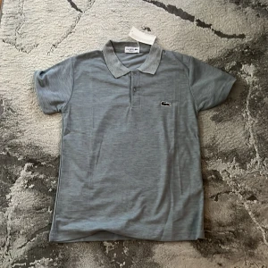 Grå pikétröja från Lacoste - Snygg grå pikétröja från Lacoste, Den passar storleken xs/s de beror på hur du vill den 