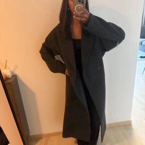 Mörkgrå lång kappa - Nästan aldrig använd, säljer pga att jag har för många kappor. Nypris 1500. Jag har vanligtvis xs/s, men denna passar även m, det är oversize fit.
