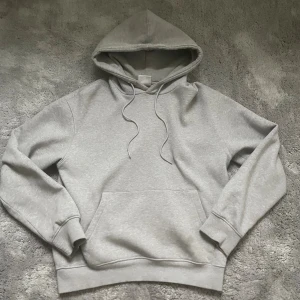 Grå hoodie från Bershka XS - Säljer en enkel och snygg grå hoodie från Bershka i storlek XS. Tröjan har huva med snörning, stor magficka och ribbade muddar vid ärmslut och nederkant. Perfekt för chill dagar och streetstyle. Mjuk insida för extra komfort.