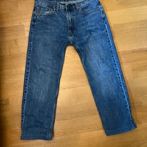 Levi's 555 blå jeans straight fit - Klassiska blå Levi's 555 jeans med relaxed fit och raka ben. Jeansen har fem fickor, gylf med dragkedja och ikonisk läderpatch bak i midjan. Perfekt för dig som gillar en avslappnad och tidlös stil.