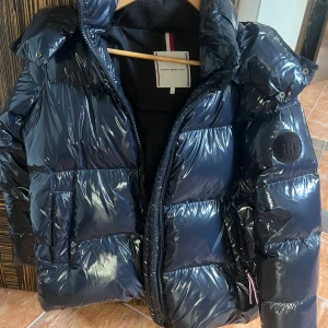 Glansig Tommy Hilfiger jacka - En super snygg glansig vinter jacka från Tommy Hilfiger i storlek S. Säljer för att jag inte får någon användning av den. Nypris ca 4700kr