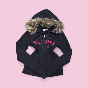Hollister Fur Hoodie - ✨ Säljer en unik fur hoodie från märket (Hollister) ✨ Pälsen är ditsatt i efterhand för en personlig och trendig look. Storleken är (S), men den kan även passa (Xs) beroende på önskad passform. Eftersom plagget är second hand kan mindre defekter jag missat förekomma! – se gärna min bio för mer info.  💎 Priset är fast och ej förhandlingsbart.  Tvättråd: Handtvätta i ljummet vatten, var försiktig med pälsen, alternativt tvätta tröjan i en tvättpåse i tvättmaskinen 30-40grader. Undvik torktumlare. 