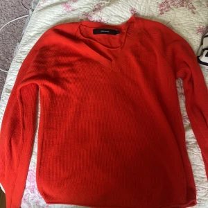 Röd stickad V-ringad tröja Vero Moda - Säljer en snygg röd stickad tröja från Vero Moda i storlek XS. Tröjan har V-ringning, lång ärm och ribbade muddar. Perfekt för dig som vill ha en enkel men färgstark baströja till garderoben.