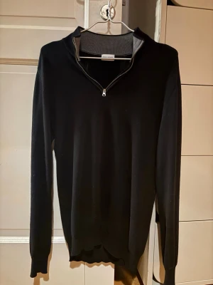 Half zip tröja John Henric - Svart stickad half zip från John Henric. Tröjan är i mjukt material.