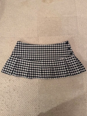 Minikjol med knappar - Super söt rutig minikjol med knappar på sidan!!! Köpt på vinted för länge sen men säljer för att jag inte gillar rutor så mycket och den används sällan💔 Mycket bra skick och inga defekter!! Den passar mig som har xs men det är storlek s tror jag (står inte) 