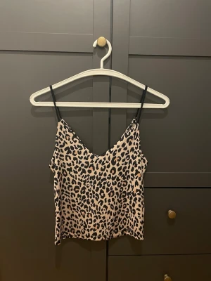 Linne med leopardmönster - Säljer en snygg linnetopp med leopardmönster, axelbanden är svarta. Är från Bik Bok i storlek XS. Pris kan diskuteras, hör av er vid intresse! 