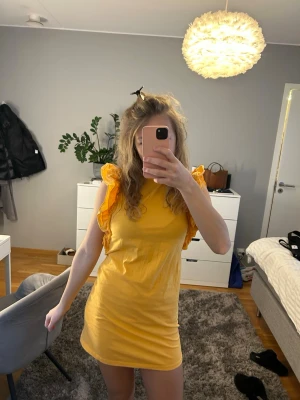 Orange volangklänning - Superfin orange kortklänning från Gina Tricot i storlek S med volangdetaljer. Klänningen är i jättebra skick. Perfekt för sommarens alla tillfällen och ger en färgboost till garderoben.