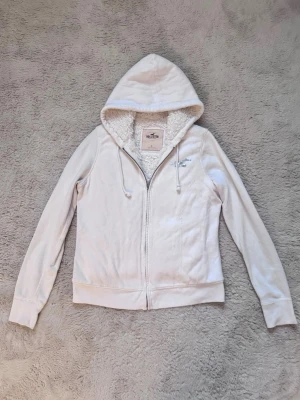Vit zip up Hoodie Hollister fodrad  - Vit zip up Hoodie ifrån Hollsiter med vitt foder! I storlek L, liten i storlek! 