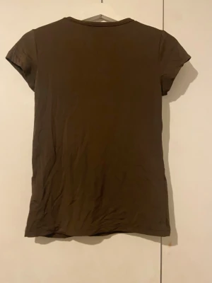 Brun basic t-shirt i bomull - En brun silk känslig tajt tröja från lager 157. I storlek M/L. 