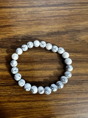 Stiligt armand  - Stliligt armband med vita och gråmelerade pärlor, passar till allt!