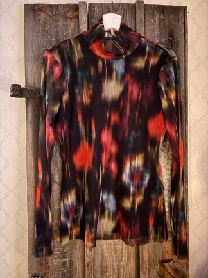 Mönstrad blus/polotopp från Baum und Pferdgarten - Snygg långärmad blus/polotopp från Baum und Pferdgarten i storlek L. Toppen har ett färgstarkt abstrakt mönster i svart, rött, gult och blått. Tillverkad i återvunnen polyester med stretch för en tight passform och hög hals.