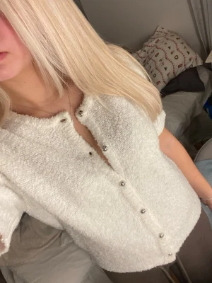 Vit  kofta  - Mysig vit kofta från Gina Tricot i storlek M passar S. Koftan har korta ärmar, rund hals och är gjord i ett fluffigt stickat material. Den stängs med silvriga knappar framtill.