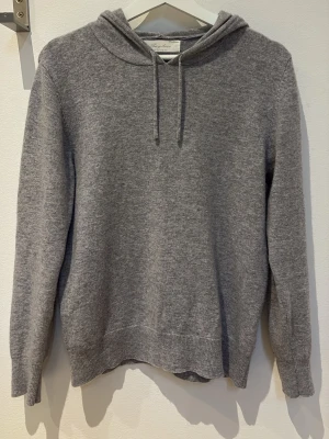 Hoodie från sayless - Säljer en stilren grå kashmir hoodie från sayless. Hoodien har dragsko i huvan, ribbade muddar vid ärmslut och nederkant samt en relaxed passform. Perfekt för en chill och avslappnad look.