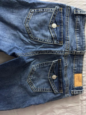Bootcut Jeans - Säljer ett par mörkblåa jeans från Gina tricot. Jeansen är lågmidjade och är i storlek 38. Inga tecken på användning. Ny pris 500