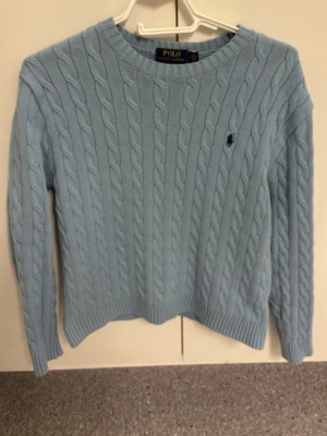 Ljusblå kabelstickad Ralph Lauren - Så gott som ny , inte använd x antal många gånger , storleken är medium men passar en lite större Small, inga defekter på den väldigt fint skick
