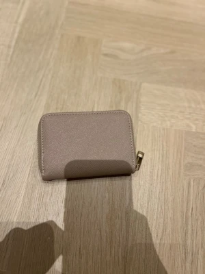 Beige plånbok med dragkedja - Säljer denna jättefina plånboken pågrund av inte nån användning, den är super fin och as bra för man får plats med allt💕