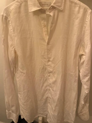 Vit linneskjorta från Massimo Dutti - Klassisk vit skjorta från Massimo Dutti i svalt linne. Skjortan har lång ärm, knappar framtill och en tidlös krage. Perfekt för en clean och stilren look, lätt att matcha med jeans eller annat.